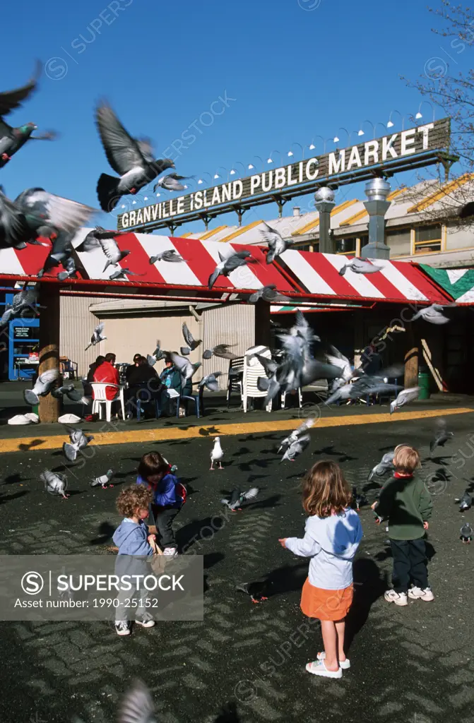 Granville Island market, kids feeding pigeons, Vancouver, British Columbia, Canada