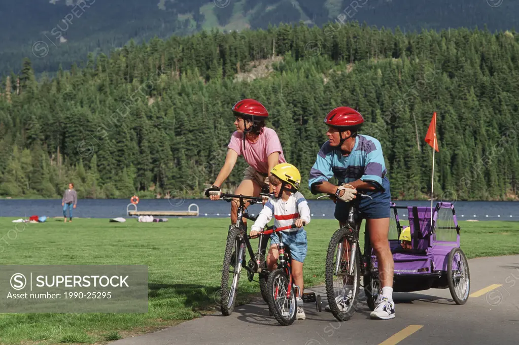 family cycles on paved trails rest at Rainbow Park, Whistler, British Columbia, Canada
