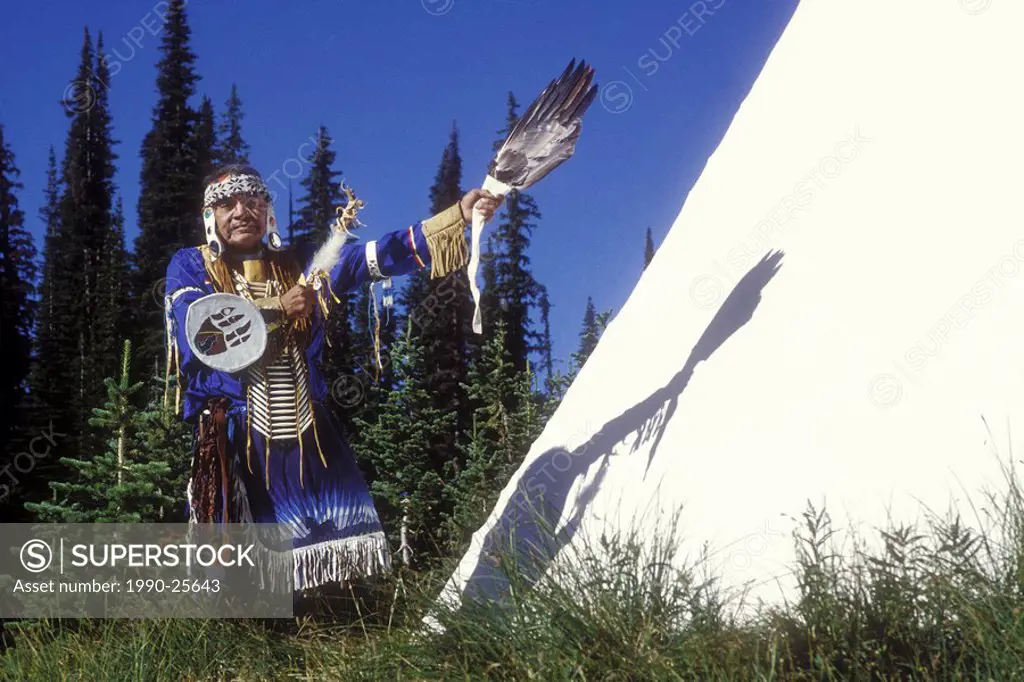 First Nations men in Indigenous regalia by their Tipi, British Columbia, Canada