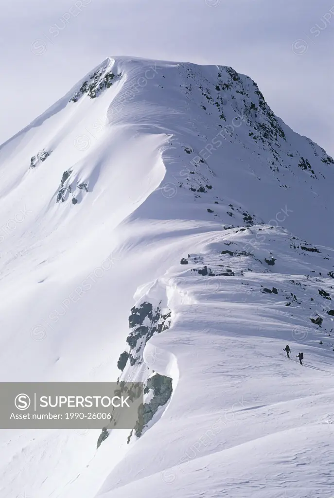 Skiers ascend a ridgeline on the spearhead traverse, a ski traverse between Blackcomb and Whistler Mountains, Whistler, British Columbia, Canada