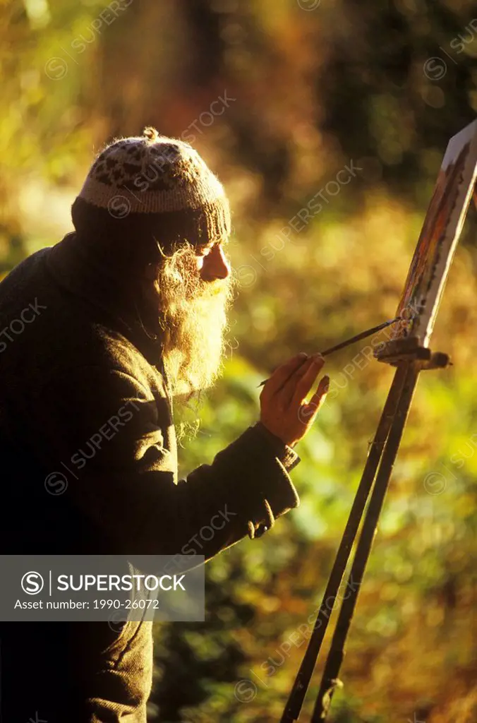 Artist painting in golden light, Nelson, British Columbia, Canada