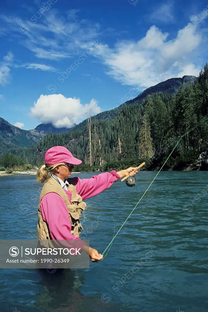 Lady flyfisher casting for salmon, Giltoyees river, Douglas Channel, British Columbia, Canada