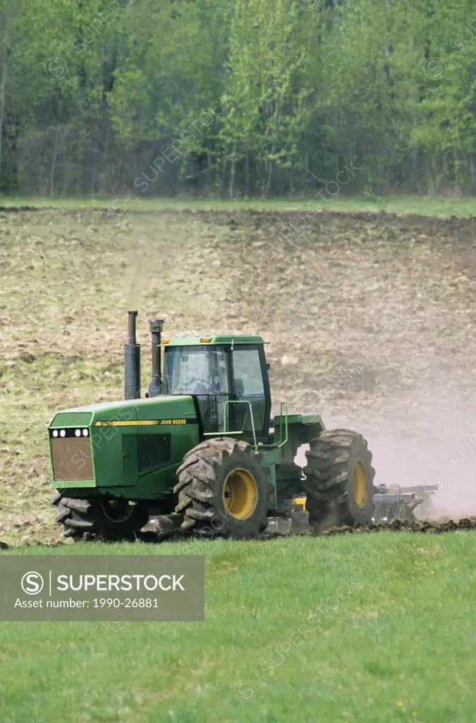 Farmer tilling a field in Smithers, British Columbia, Canada