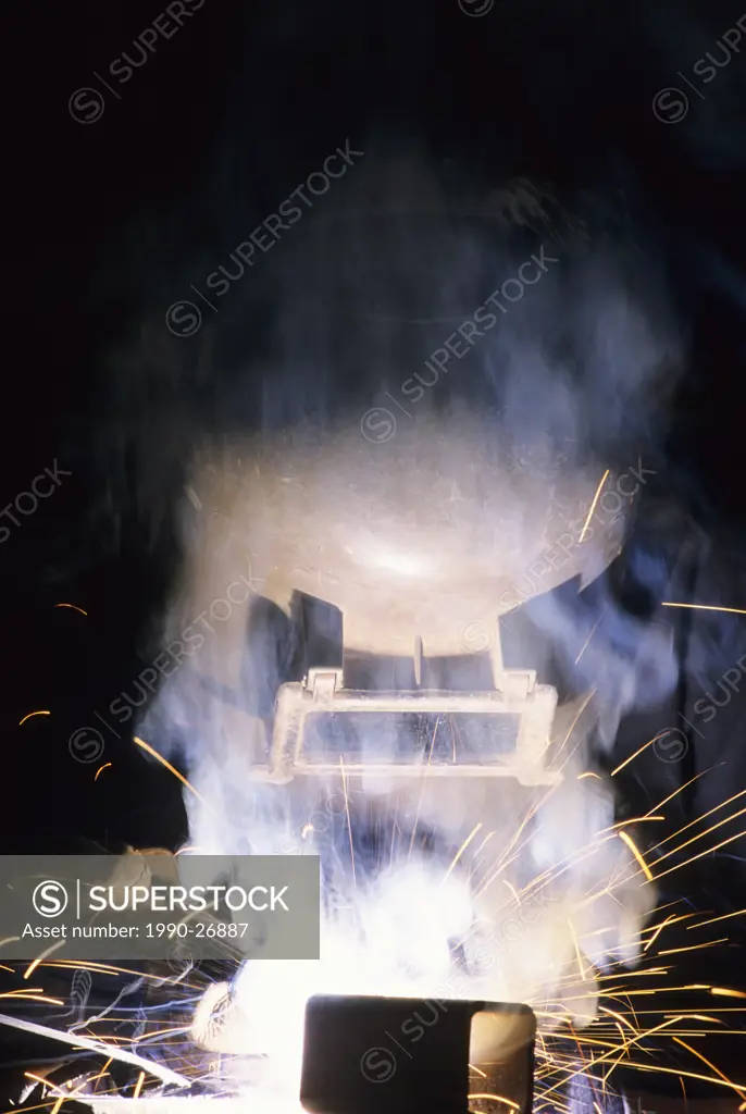 Welder in mask at work, Smithers, British Columbia, Canada