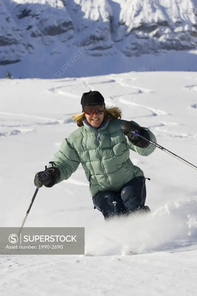 Young woman skiing fresh untracked powder at Fernie Alpine Resort, Fernie, British Columbia, Canada