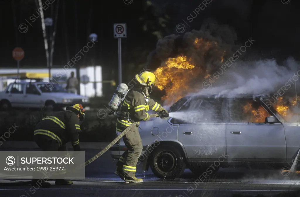 Firemen douse burning vehicle at UNBC, British Columbia, Canada