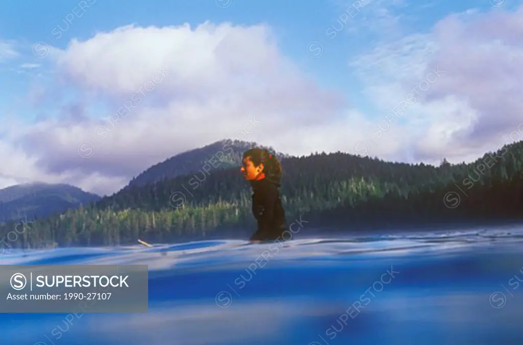 Female waiting for waves while surfing near Tofino, Vancouver Island, British Columbia, Canada