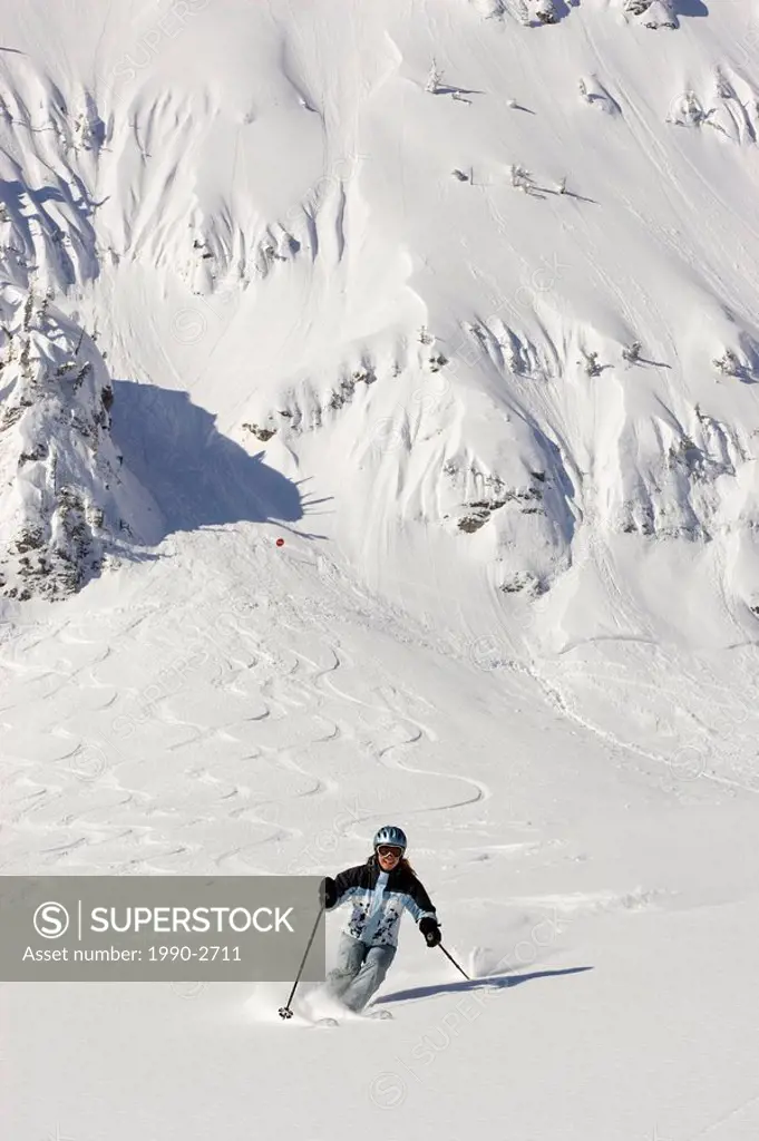 Young woman skiing fresh powder at Fernie Alpine Resort, Fernie, British Columbia, Canada