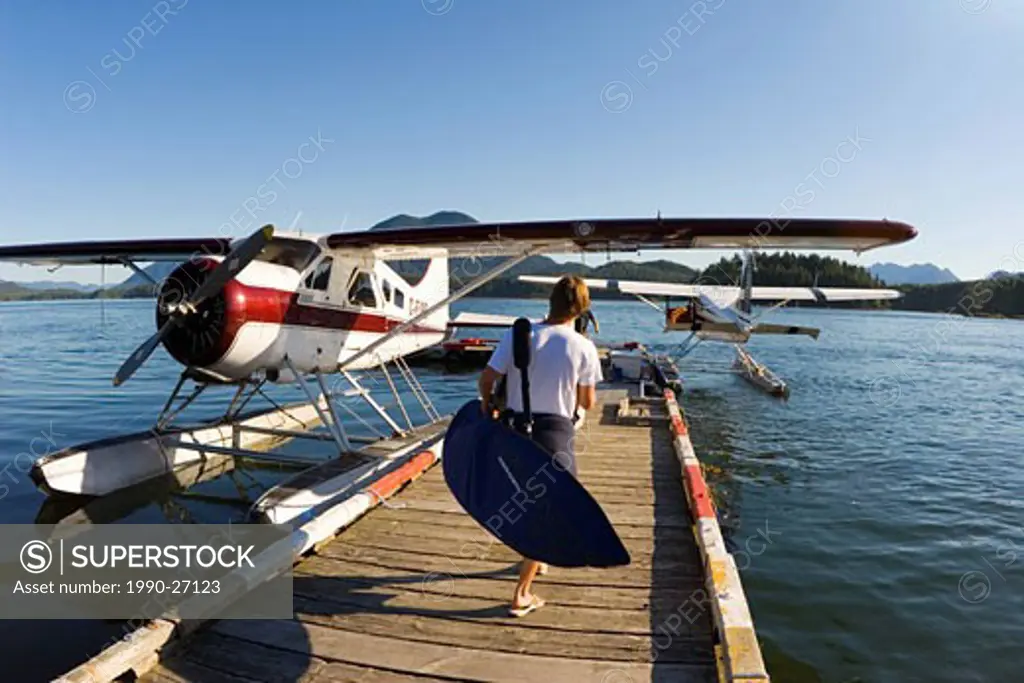 Surfer leaving on a flight in search of waves, Tofino, Vancouver Island, British Columbia, Canada