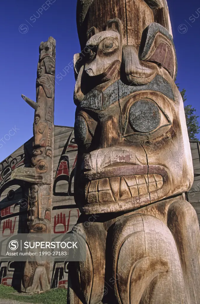 Ksan Historical Village, a reconstructed traditional Gitxsan village on the banks of the Skeena River in the foreground is the ´Bear Mother´ pole, nea...