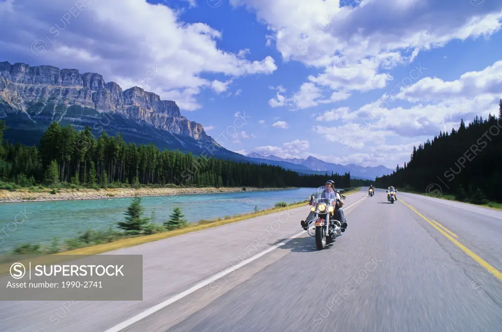 Motorcyclists along Highway One, Castle Mountain and the Bow River beyond, Alberta, Canada