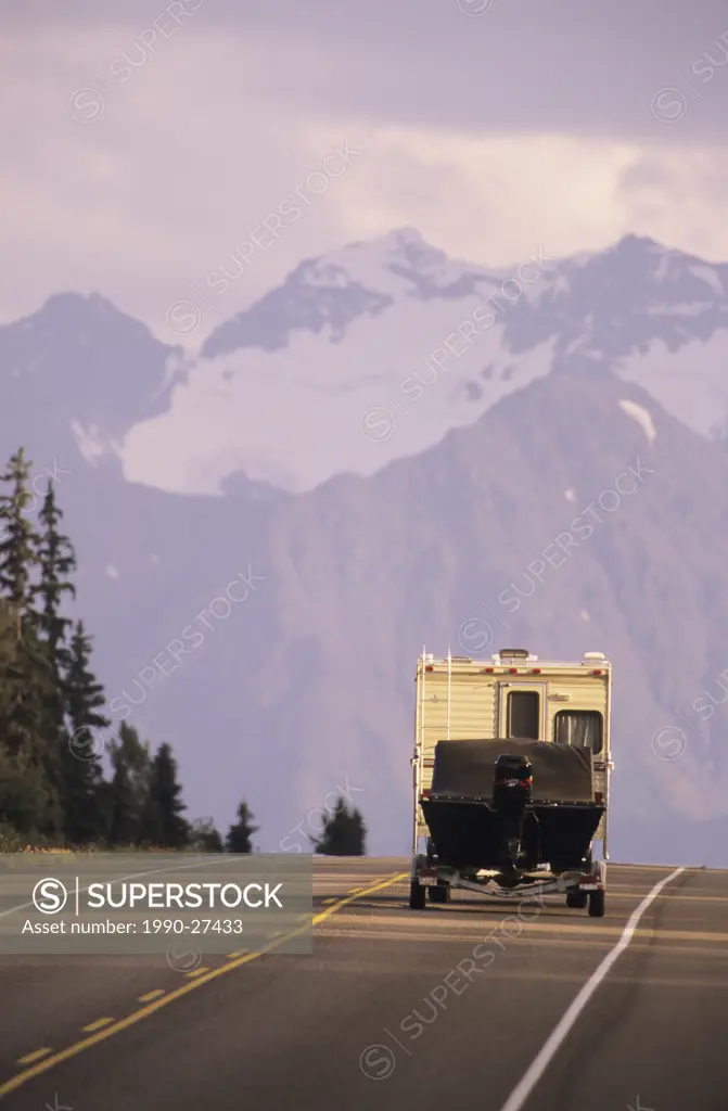 Camper and boat trailer on Highway 16 near Smithers  Hudson Bay mountain in background, British Columbia, Canada