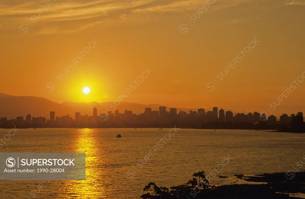 Vancouver skyline and the Coast Mountains from Kitsilano Beach at sunrise, Vancouver, British Columbia, Canada