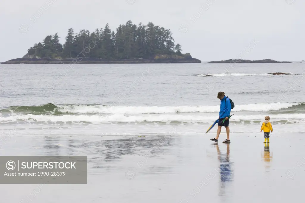 father and son walk shoreline, MacKenzie Beach at Tofino, Vancouver Island, British Columbia, Canada
