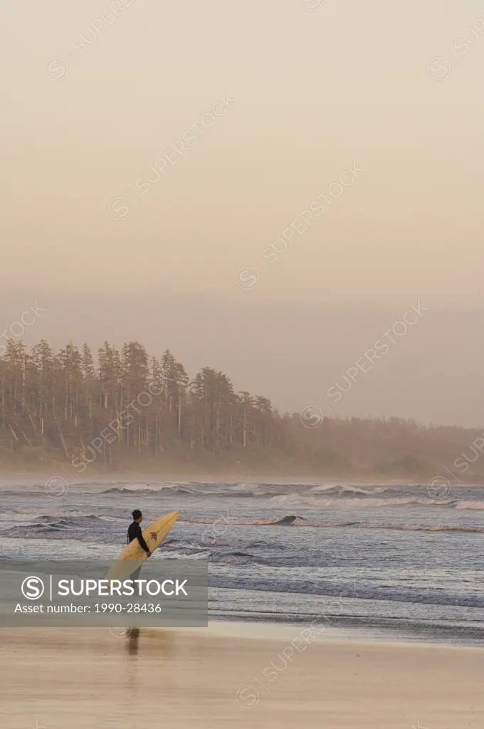 Surfer standing on shoreline, Pacific Rim National Park, Long Beach, Vancouver Island, British Columbia, Canada