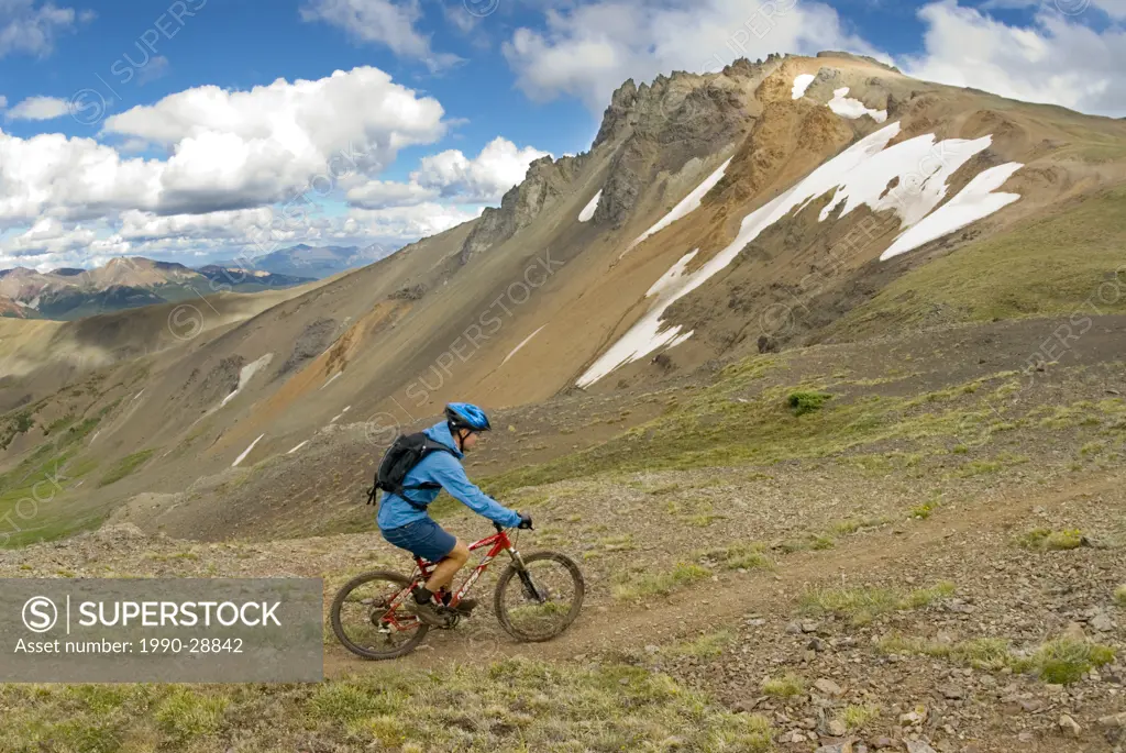 Mountain biker rides his bike up the trail to Deer Pass, Southern Chilcotin Mountains, British Columbia, Canada.