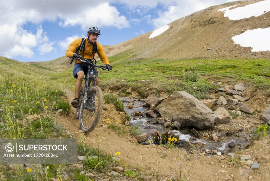 Mountain biker rides the trail down from Deer Pass, Southern Chilcotin Mountains, British Columbia, Canada.