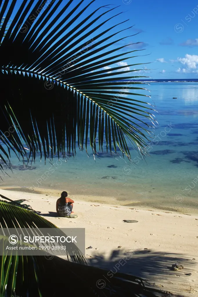 Cook Islands, South Pacific, local woman sits on tropical beach, Rarotonga