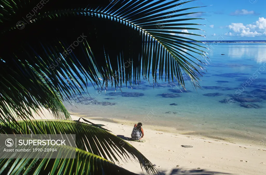 Cook Islands, South Pacific, local woman sits on beach, Rarotonga