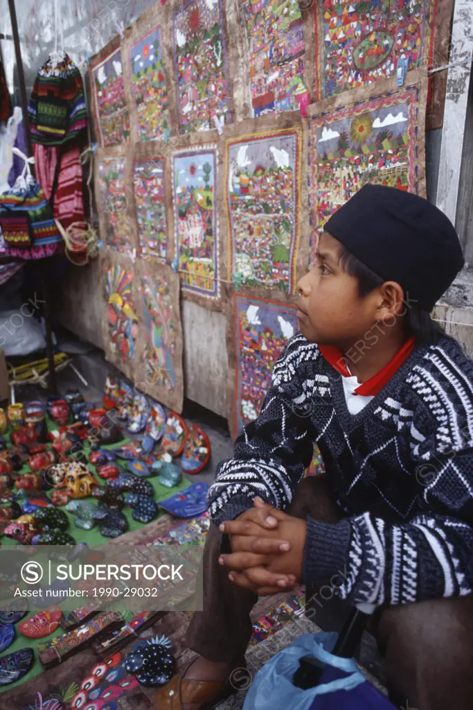 Mexico City, boy selling wares on street side market stand