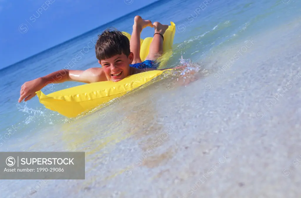 Mexico, Yucatan Peninsula, Carribean resort at Isla Mujeres, boy with float mattress
