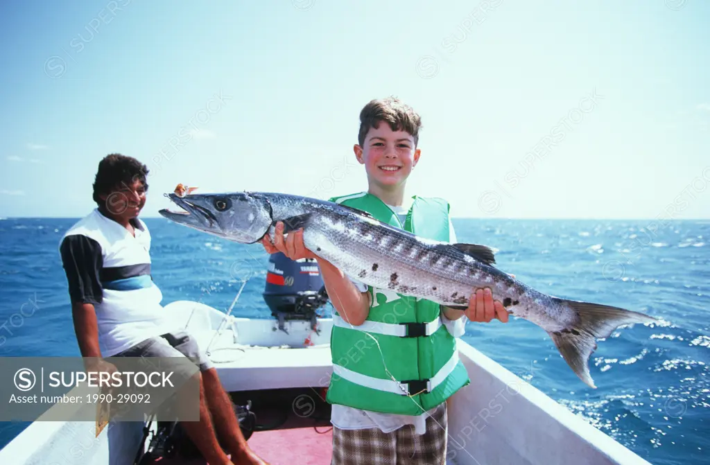 Mexico, Yucatan Peninsula, Carribean resort at Isla Mujeres, boy with barracuda
