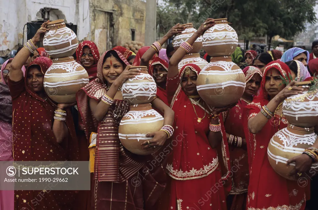 India, Rajastan, Jaipur, women at pre wedding ceremony with earthen ware jugs