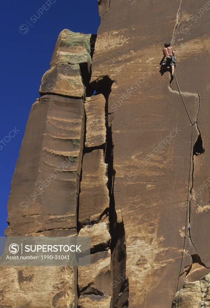 A climber leading his way up the cracks on Way Rambo 5.12a, Indian Creek, Utah, USA