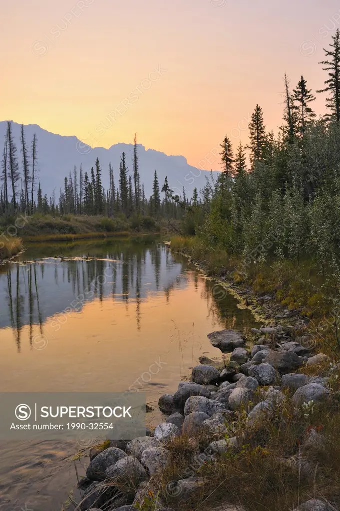 This warm tone vertical landscape image was captured early one morning in Jasper National Park as the rising sun was comming slowly over the mountains...