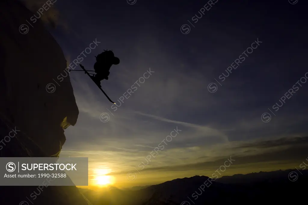 Skiier jumps cliff at twilight Whistler, BC, Canada