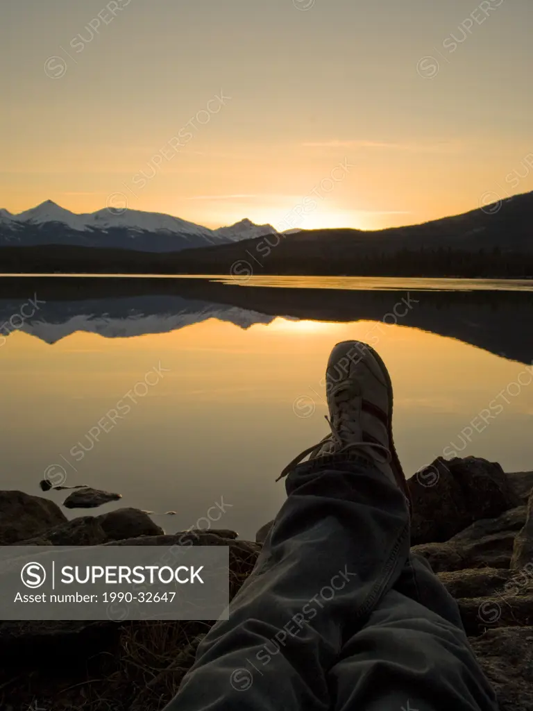 Photographer kicks back to watch the sunset on the shore of Pyramid Lake, near Jasper, Alberta, Canada.