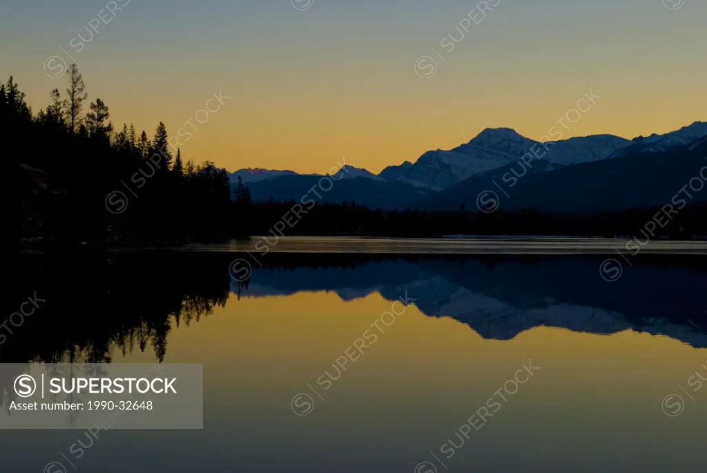 Sunset outlines the majestic Mt. Edith Cavell behind Pyramid Lake near Jasper, Alberta, Canada.