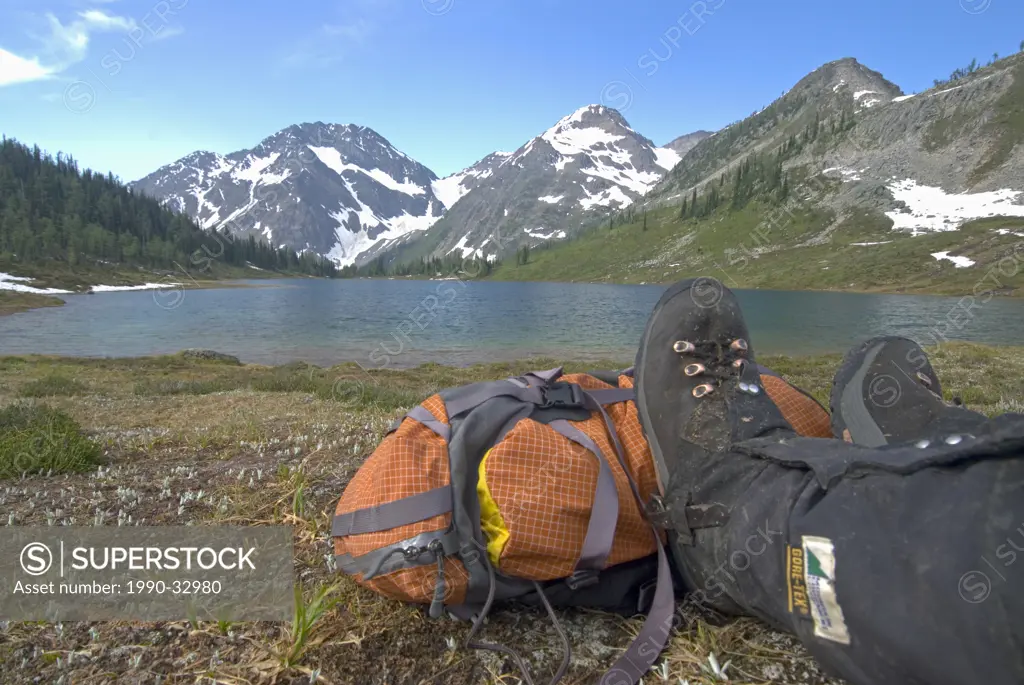 A hiker relaxing on the shores of a remote lake in British Columbia, Canada