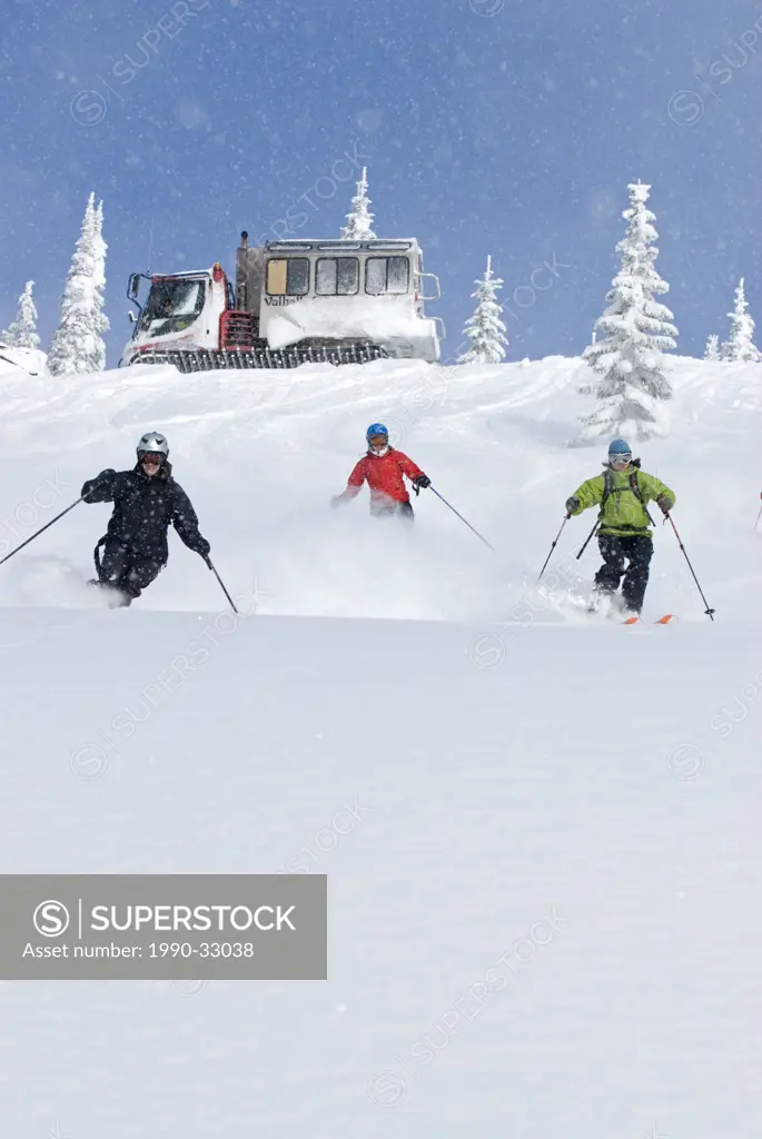 Skiers descend below the snowcat on a pristine slope, Valhalla Powdercats, British Columbia