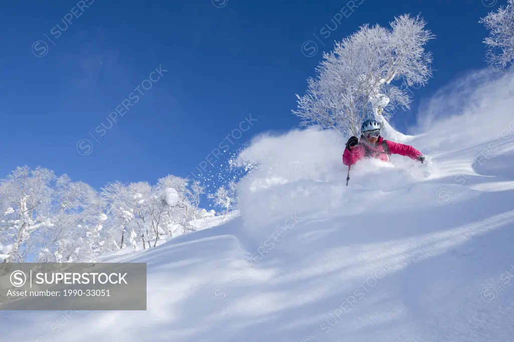A female skier in deep powder at Asahidake Ropeway ski area, Hokkaido, Japan
