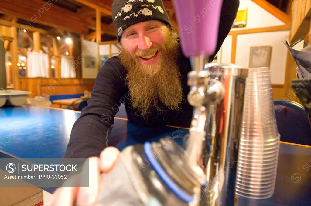 A happy hippy skier fills up his water bottle with beer at Whitewater Winter Resort, British Columbia