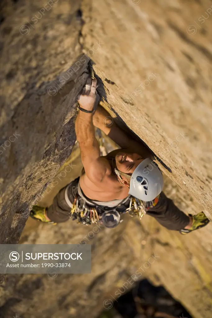 A young man climbs a crack climb at Skaha Bluffs in Penticton, BC