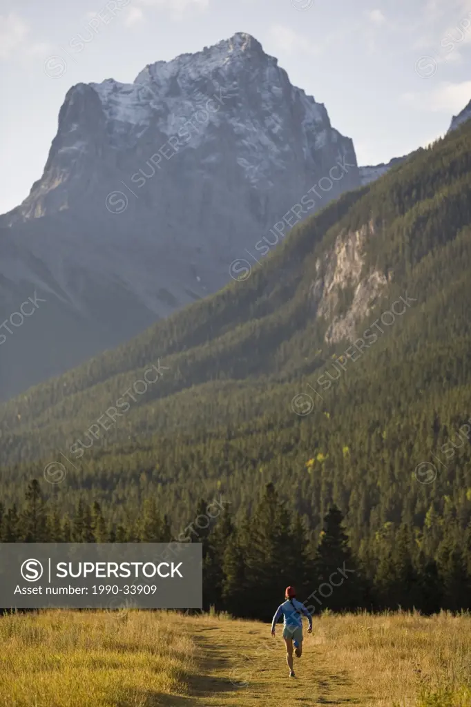 A young woman trail running in Canmore, AB