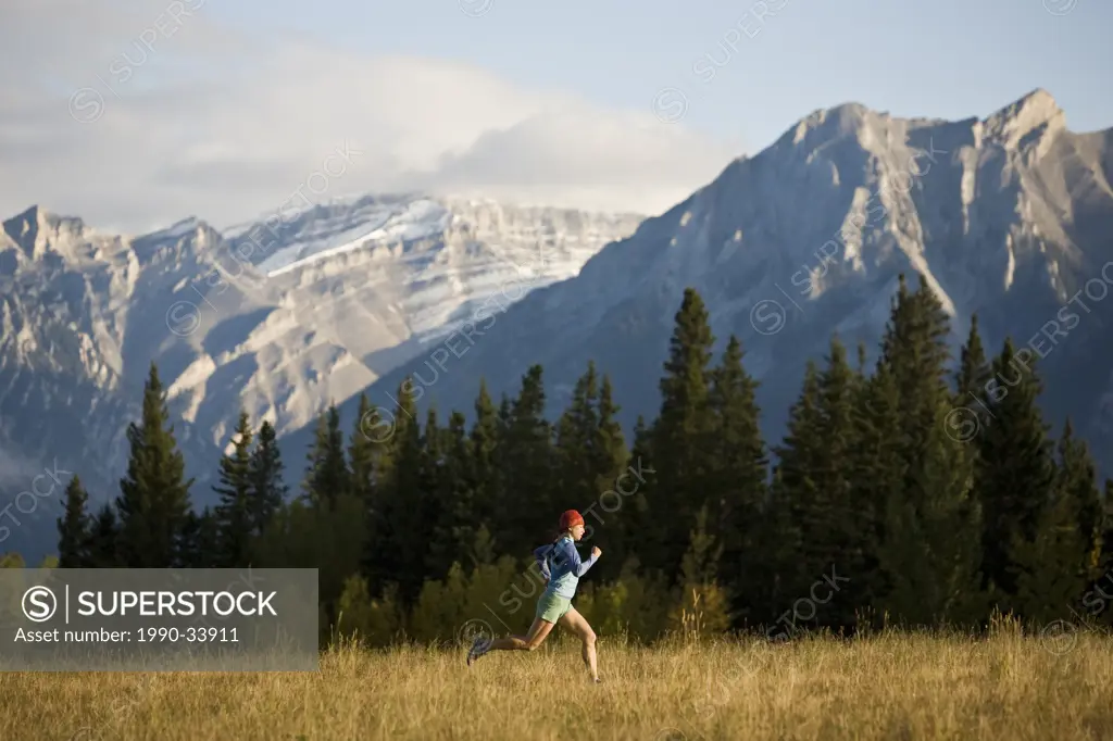 A young woman trail running in Canmore, AB