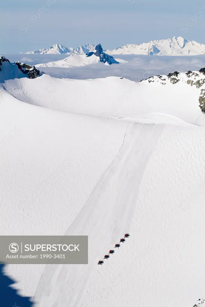 aerial of snow cats on blackcomb glacier with black tusk and tantalus range in background, british columbia, Canada
