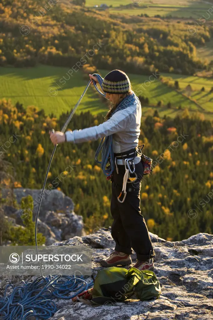 A young woman rockclimbing in Kamouraska, QC