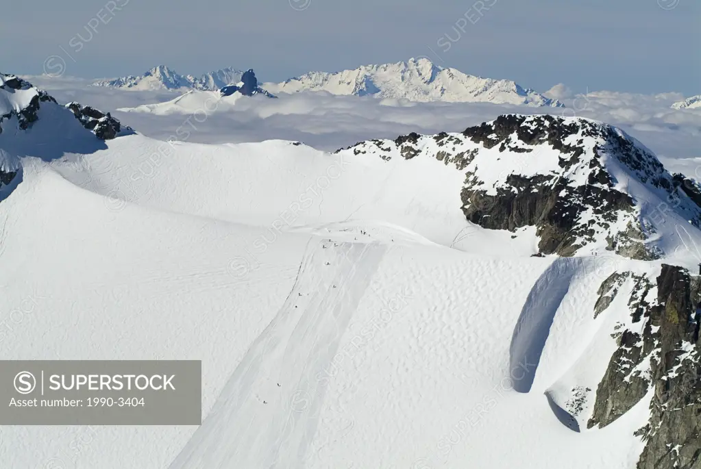 aerial of skiers on blackcomb glacier with black tusk and tantalus range in background, british columbia, Canada