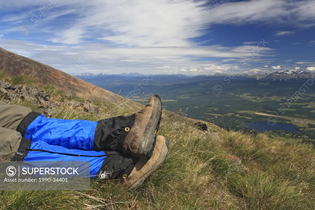 Wide angle view of hikers boots in alpine area overlooking the Bulkley Valley, Smithers, British Columbia