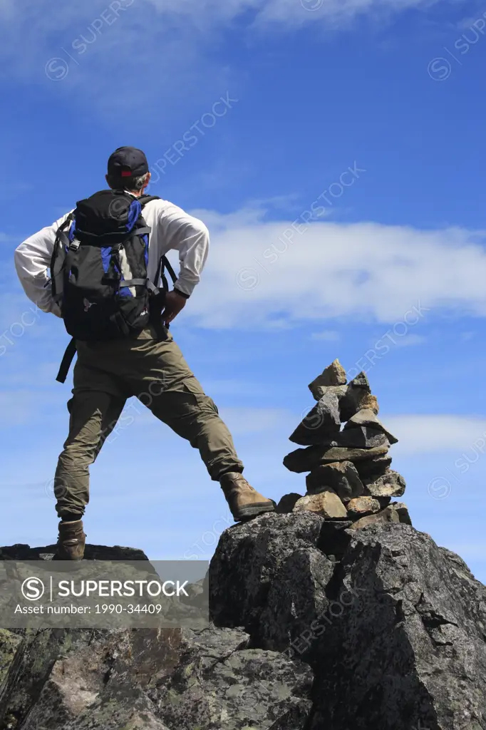 Hiker and rock cairn on trail, Hudson Bay Mountain, Smithers, British Columbia