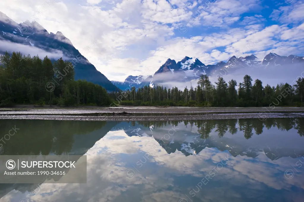 Coast mountains reflected in the Taku river, British Columbia, Canada