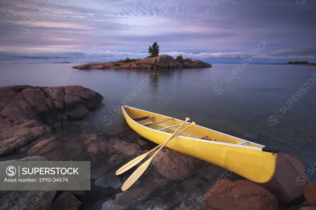 Canoe by granite islands of Georgian Bay, Killarney Provincial Park, Ontario