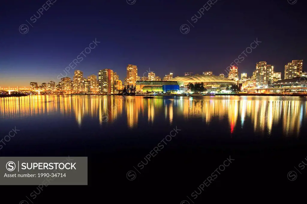 The view across False creek to downtown Vancouver and BC Place Stadium at night. Vancouver British Columbia Canada.