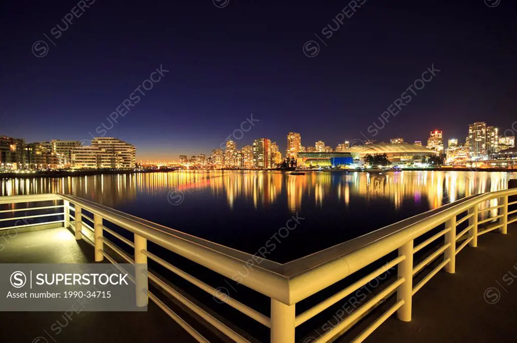 The view across False creek to downtown Vancouver and BC Place Stadium at night. Vancouver British Columbia Canada.