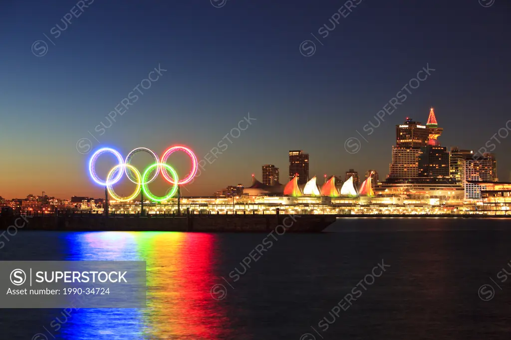 The Olympic Rings light up Coal Harbor/Harbour in front of Canada Place and downtown Vancouver at dawn. Vancouver British Columbia Canada.