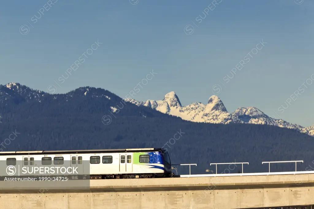 Against a backdrop of the Lion´s and North Shore, the Canada Line light rapid transit crosses the Fraser River into Richmond. Vancouver British Columb...